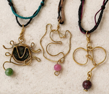 Three handmade brass Initial Talismans necklaces with the letters A, M and E, semiprecious stones and adjustable macramé cords.