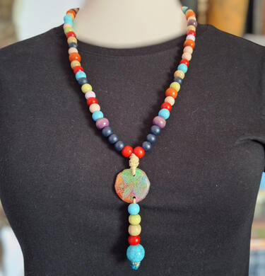 Handmade Grape and Blackberry necklace from the Road Talismans collection, crafted with colorful beads, cord and a round pendant.